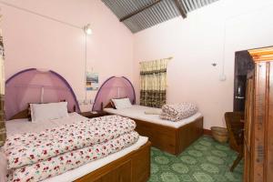 מיטה או מיטות בחדר ב-Piprahar Community Homestay