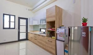 a kitchen with a stainless steel refrigerator and wooden cabinets at Art Ocean B&B in Yujing