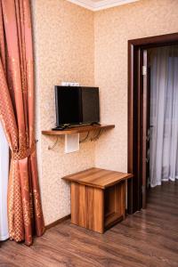 a room with a tv and a table and a door at Liberty Fly Hotel in Adler