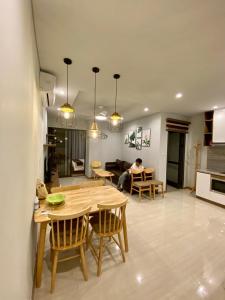 a room with a table and chairs and a person sitting in a kitchen at Khánh Phong Homestay Greenbay Garden Hạ Long in Ha Long