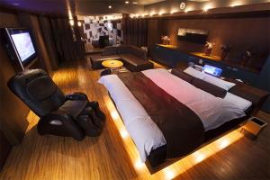 Hotel Oarai Seven Seas(Adult Only) في واراي: غرفة نوم كبيرة مع سرير كبير وكرسي