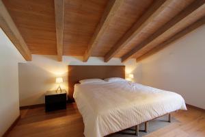 ein Schlafzimmer mit einem großen Bett und Holzdecken in der Unterkunft Les Fleurettes in Le Châble