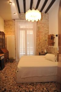 a bedroom with a large bed and a chandelier at 3C B&B in Venice