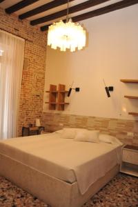 una camera con un grande letto e un lampadario a braccio di 3C B&B a Venezia