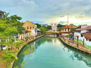 a river in a city with houses and buildings at Lavender@Guesthouse in Malacca