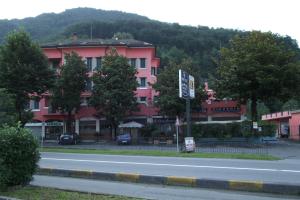 un grande edificio rosa sul lato di una strada di Hotel Total a Pisogne