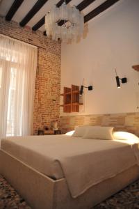 a bedroom with a large bed and a brick wall at 3C B&B in Venice