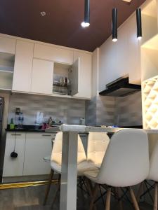 a kitchen with white cabinets and a table and chairs at SHP Plaza Khanh Phong Homestay in Hai Phong
