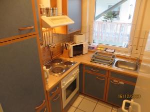 eine kleine Küche mit einer Spüle und einer Mikrowelle in der Unterkunft Ferienwohnung am Hofgarten in Langenfeld
