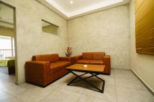 a living room with two chairs and a table at Windale Resorts in Pooppara