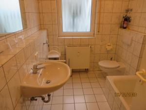 a white bathroom with a sink and a toilet at Ferienwohnung am Hofgarten in Langenfeld +20 photos
