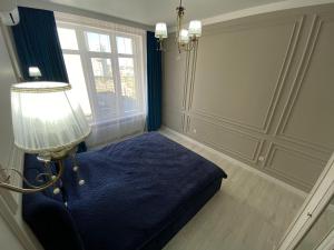 a room with a bed and a lamp and a window at ЖК ‘ZAMAN’ in Atyrau