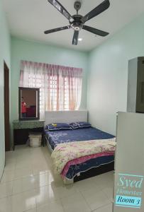 a bedroom with a bed and a ceiling fan at Syed Homestay Arau in Arau