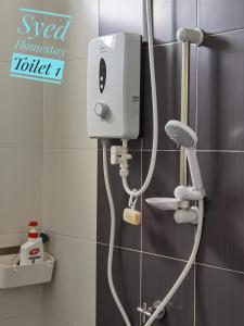 a shower in a bathroom with a hair dryer at Syed Homestay Arau in Arau