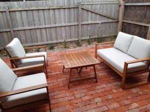 dwa krzesła i stolik kawowy na ceglanym patio w obiekcie The Weekender w mieście Peterborough