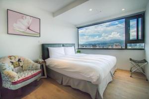 a bedroom with a bed, chair and a painting on the wall at NK Hostel in Taipei