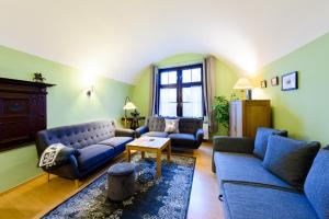 ein Wohnzimmer mit blauen Sofas und einem Tisch in der Unterkunft Ferienwohnungen Burg im Zwinger in Goslar