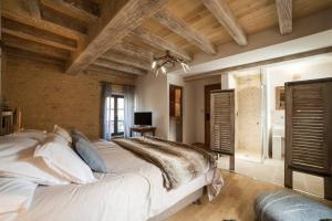 una camera da letto con un grande letto bianco e soffitti in legno di Le Clos des Songes a Saint-Léon-sur-Vézère