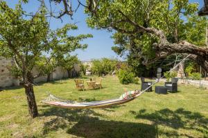 una hamaca colgando de un árbol en un patio en Villa Lotus, en Melissano