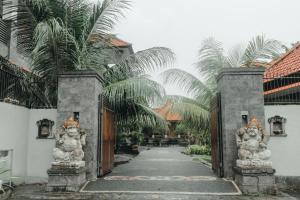 an entrance to a house with palm trees at Hotel Diana 2 in Kesiman