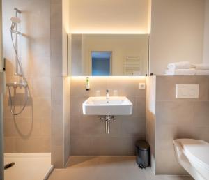 a bathroom with a sink and a shower at Hotel Augustyn Brugge in Bruges