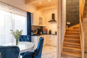 kuchnia ze stołem i krzesłami oraz schody w obiekcie Luxury Houses & Apartments Zaliński w Zakopanem