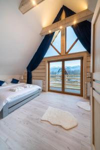 una camera con un letto e una grande finestra di Luxury Houses & Apartments Zaliński a Zakopane