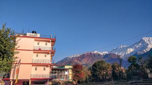un edificio alto con montañas en el fondo en Sakura Guest House en Dharamshala