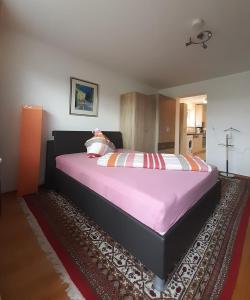 a bedroom with a large bed with pink sheets at Familie Ohneberg in Hard