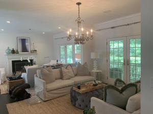 a living room with a couch and a chandelier at Villa Zainip - Luxury with pool in Sag Harbor