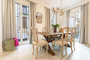 een eetkamer met een houten tafel en stoelen bij Genteel Home Feria in Sevilla