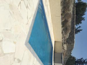 a large blue swimming pool on the side of a building at Orchard View Cottage in Maroni