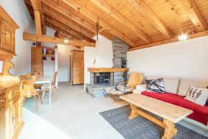 sala de estar con sofá rojo y techo de madera en Casa Ansiel, en Falera