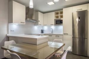a kitchen with a table and a stainless steel refrigerator at Casa Tiago in Santa Cruz de Tenerife