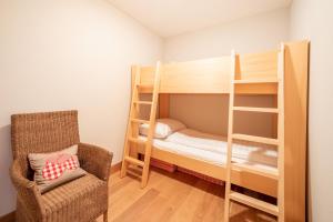 フリムスにあるVia Surpunt 20A - A1- Bruwerの小さな客室で、二段ベッド1組、椅子が備わります。