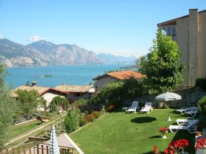 a garden with chairs and a view of the water at Casa Mary in Brenzone sul Garda