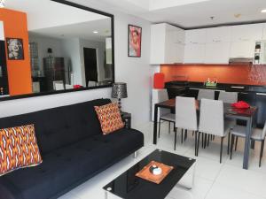 a living room with a black couch and a table at Lagoon view Family Suite in Pico De Loro Cove, Nasugbu in Nasugbu