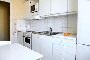 een keuken met witte kasten en een spoelbak bij Apartment Hotell Conrad in Karlskrona +28 foto's