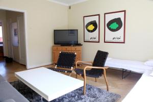 een woonkamer met 2 stoelen en een televisie bij Apartment Hotell Conrad in Karlskrona