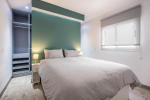 a bedroom with a large bed and a window at Casa Tiago in Santa Cruz de Tenerife