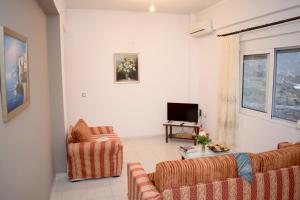 ein Wohnzimmer mit 2 Sofas und einem TV in der Unterkunft Niki's House in Asómatoi