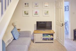 a living room with a couch and a television at Host & Stay - Richemont Cottage in Whitby