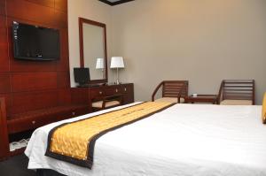 a hotel room with a large bed and a television at Monte Carlo Hotel Hai Phong in Hai Phong