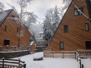 a building with snow on the ground next to it at Brezovica Luxury Villa, Brezovicë in Brezovica