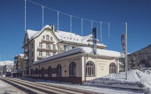 a large building with snow on top of it at Hotel Montana by Mountain Hotels in Davos