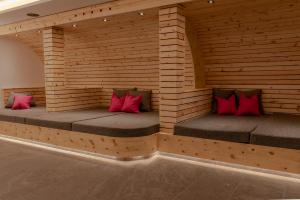 two beds in a wooden room with red pillows at Hotel Stadt Wien in Zell am See