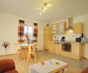 a kitchen and a living room with a table and chairs at Deinerhof in Hauzenberg