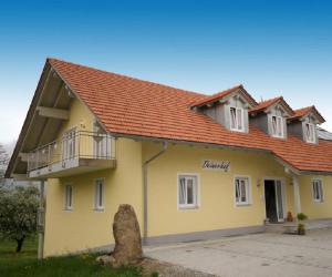 ein gelbes Haus mit orangefarbenem Dach in der Unterkunft Deinerhof in Hauzenberg