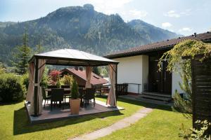 a gazebo with a table and chairs in a yard at Chalet Sabrina mit Außenpool im Sommer in Kaprun