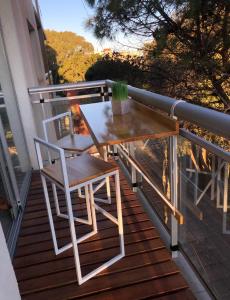 een houten tafel en stoelen op een balkon bij Departamento, San Bernardo in San Bernardo